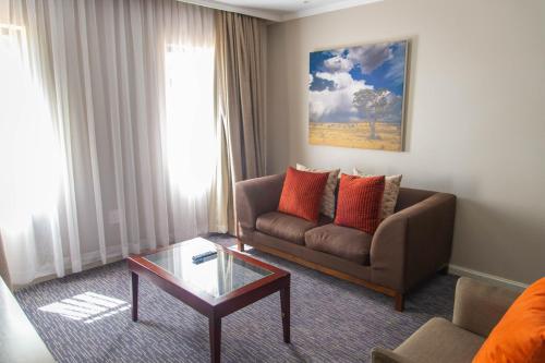 a living room with a couch and a coffee table at Cresta Mahalapye Hotel in Mahalapye