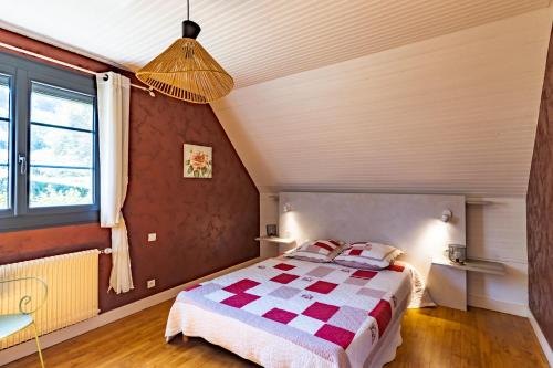 a bedroom with a bed with a checkered blanket at La Trappe in Sarlat-la-Canéda