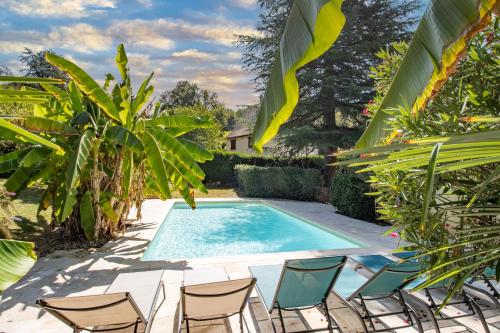 une piscine entourée de chaises et de plantes dans l'établissement La Trappe, à Sarlat-la-Canéda
