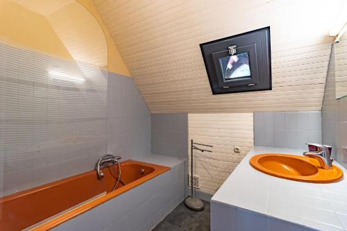 a bathroom with an orange tub and a sink at La Trappe in Sarlat-la-Canéda