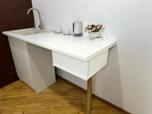 a white bathroom sink with flowers on it at Hotel Tigran Mets Yerevan in Yerevan