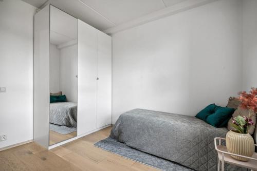 a bedroom with a bed and a mirror at child friendly 4 room apartment in Kolsås