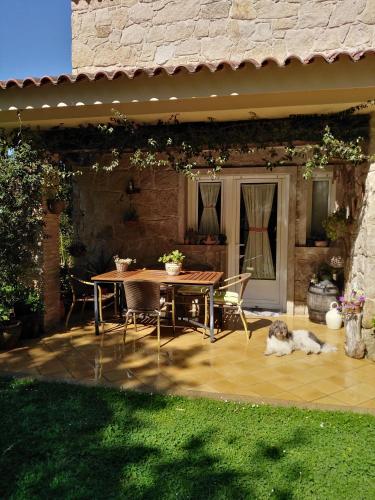 a patio with a table and a dog laying on the grass at Paradise in Vigo in Vigo
