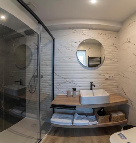 a bathroom with a sink and a shower at NOARU Apartamentos Deluxe in Ares