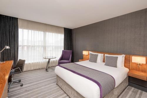 a hotel room with a bed and a desk at Crowne Plaza Newcastle - Stephenson Quarter by IHG in Newcastle upon Tyne