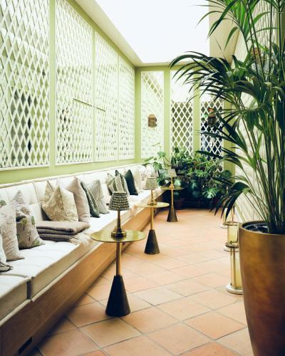 a lobby with couches and potted plants at The Adria in London