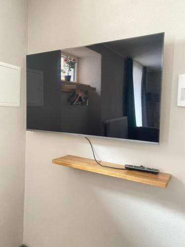 a mirror on a wall with a remote control on a shelf at Motel Q- das kleine Stadthotel in Dingolfing