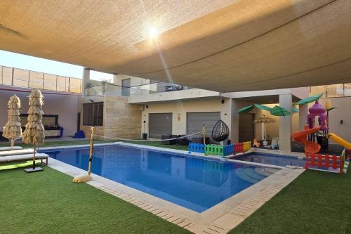 a swimming pool with a playground in a house at Jumeirah Chalet جميرا شاليه in Amman