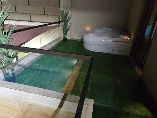 a bath tub in a room with a green floor at Jumeirah Chalet جميرا شاليه in Amman