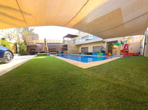 a house with a swimming pool in a yard at Jumeirah Chalet جميرا شاليه in Amman