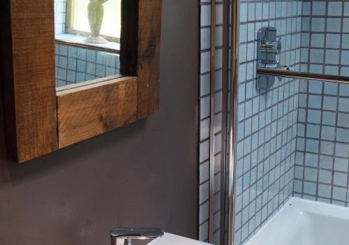 a bathroom with a sink and a mirror and a tub at The Barn at Star Chamber Farm in Hebden Bridge