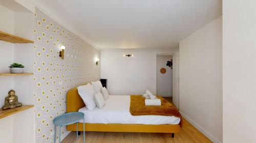 - une petite chambre avec un lit et une chaise bleue dans l'établissement Bluestay 5- Superbe appartement à Paris, à Paris