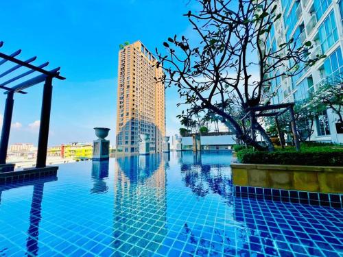une piscine au milieu d'une ville avec des bâtiments dans l'établissement Cozy Spacious 55sqm 1BR 200m BTS PhraKhanong, 10min Thonglo, à Bangkok