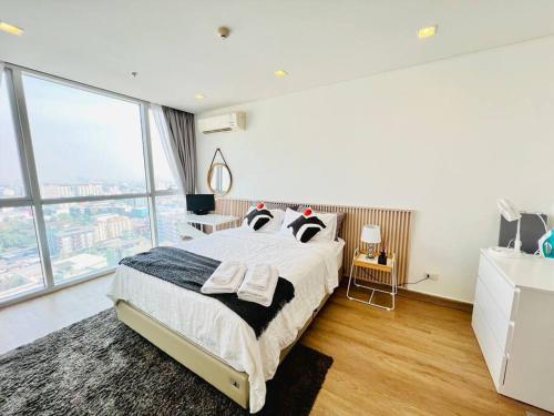 une chambre avec un grand lit et de grandes fenêtres dans l'établissement Cozy Spacious 55sqm 1BR 200m BTS PhraKhanong, 10min Thonglo, à Bangkok