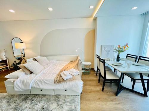 a bedroom with a bed and a dining room with a table at Cozy Spacious 55sqm 1BR 200m BTS PhraKhanong, 10min Thonglo in Bangkok