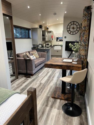 a kitchen and living room with a couch and a table at Ye Old Lambing Lodge - Spring Paddock in Stafford