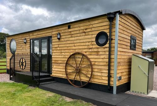 a wooden house with a large wheel on it at Ye Old Lambing Lodge - Spring Paddock in Stafford