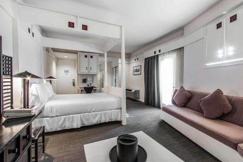 a hotel room with a bed and a couch at Inn at the Mill, an Ascend Collection Hotel in Fayetteville
