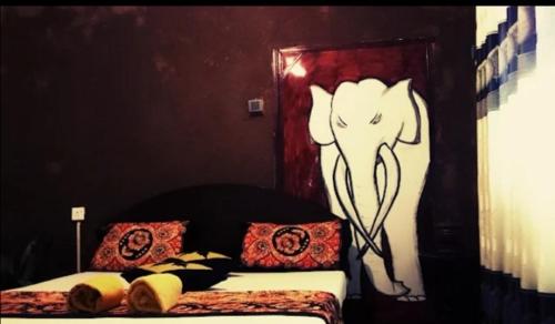 a bedroom with a bed with an elephant painted on the wall at Mystay in Mawanella