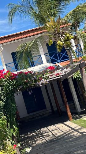 a house with a palm tree and a porch with flowers at House Maceió 1 in Maceio