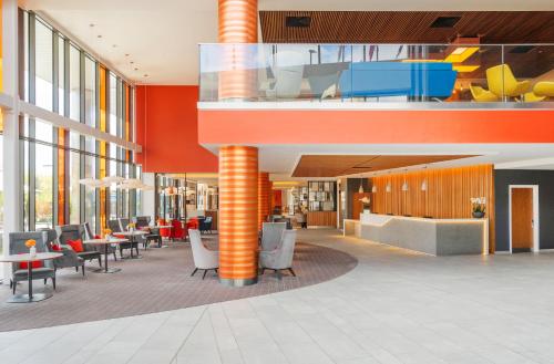 an office lobby with orange columns and tables and chairs at Crowne Plaza Newcastle - Stephenson Quarter by IHG in Newcastle upon Tyne