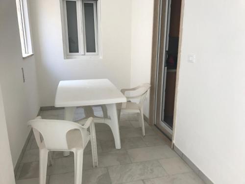 a white table and two chairs in a room at Case al mare in Salento - bilocale B8 in Marina di Leuca
