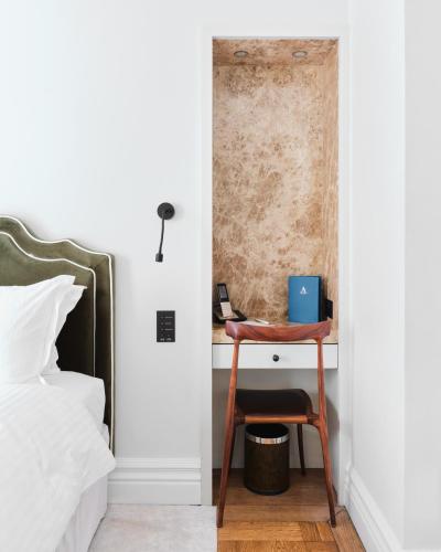 a bedroom with a bed and a desk with a phone at The Adria in London