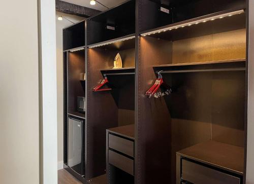 a walk in closet with black cabinets and red hangers at The Century House, an Ascend Collection Hotel in Latham