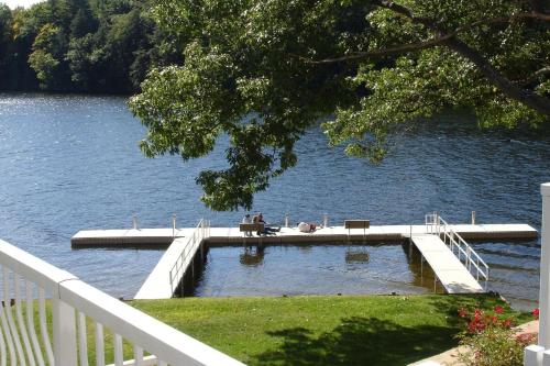 a dock on a lake with two people sitting on it at Riverside Hotel, an Ascend Collection Hotel in West Chesterfield