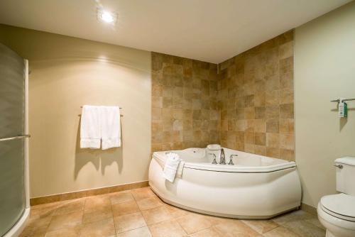 a bathroom with a tub and a toilet at Riverside Hotel, an Ascend Collection Hotel in West Chesterfield