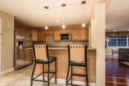 a kitchen with two bar stools in front of a counter at Riverside Hotel, an Ascend Collection Hotel in West Chesterfield