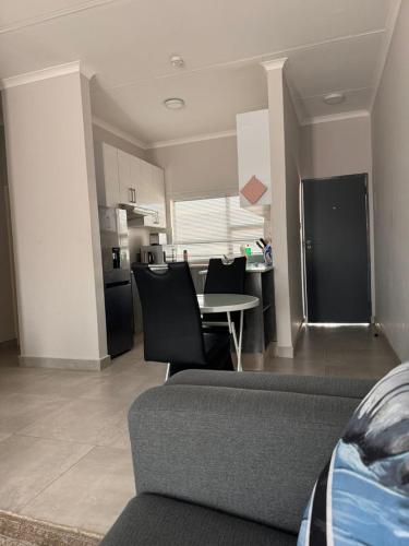 a living room with a couch and a kitchen at Kastina Suites in Gaborone