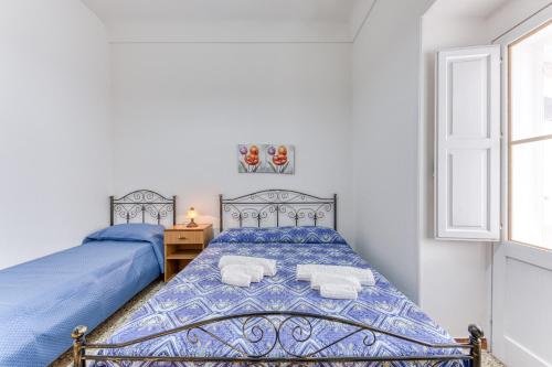 a bedroom with two beds and a window at Appartamento Lido Marini in Lido Marini