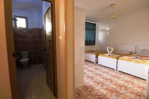 a room with two beds and a doorway at Luxor View Hostel in Luxor