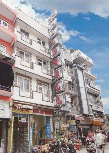 a tall white building with signs on it at Hotel All Iz Well - Traveller Choice Award winner 2025 in New Delhi
