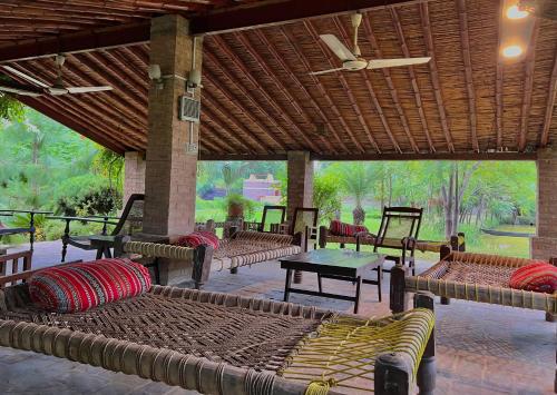 a pavilion with couches and tables on a patio at Cozy Farmhouse Retreat in Mardan
