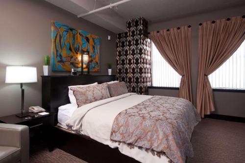 a bedroom with a bed and a couch and windows at The Giacomo, an Ascend Collection Hotel in Niagara Falls