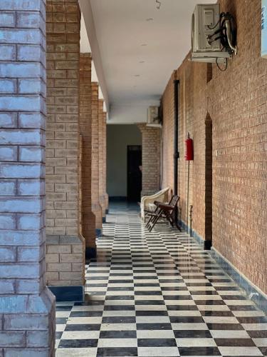 an empty hallway with a bench in a brick building at Cozy Farmhouse Retreat in Mardan