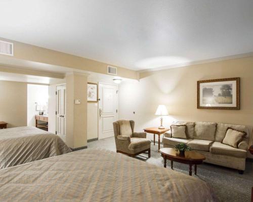 a hotel room with a bed and a couch at Liberty Hotel, an Ascend Collection Hotel in Cleburne