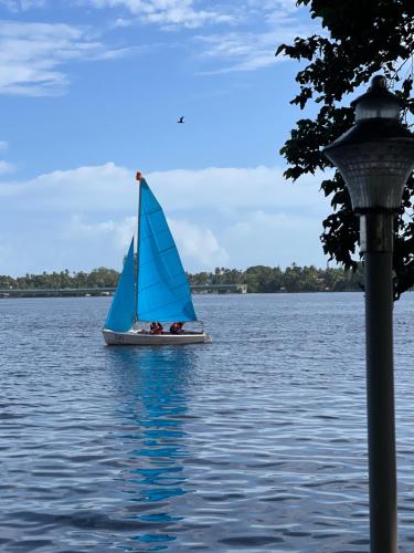 a sailboat on the water with people on it at AshtamudiVillas in Kollam