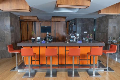 a bar in a restaurant with orange bar stools at Radisson Blu Hotel Istanbul Asia in Istanbul