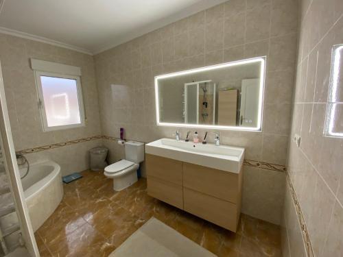 a bathroom with a sink and a toilet and a mirror at Villa SunShine Ciudad Quesada Spain in Ciudad Quesada
