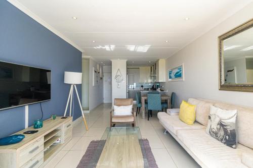 a living room with a couch and a television at Modern Seaview Apartment in Summerstrand