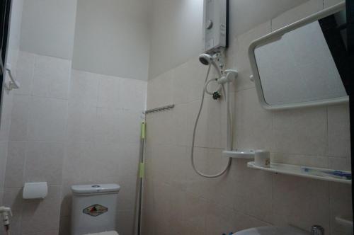 a bathroom with a shower and a toilet and a mirror at Thanh Lich Guesthouse in Quang Ngai