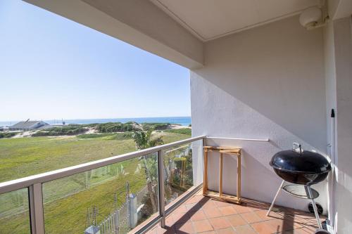 a balcony with a grill and a view of the ocean at Modern Seaview Apartment in Summerstrand