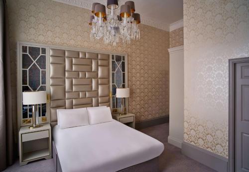a bedroom with a bed and a chandelier at Henrietta House, a member of Radisson Individuals in Bath