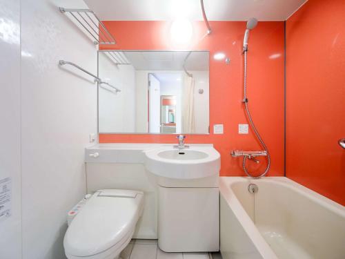 a bathroom with a toilet and a sink and a tub at Comfort Inn Kumamoto Miyukifueda in Kumamoto