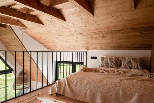 a bedroom with a large bed in a room with wooden ceilings at NOOK Cabins - Mountain View in Zakopane