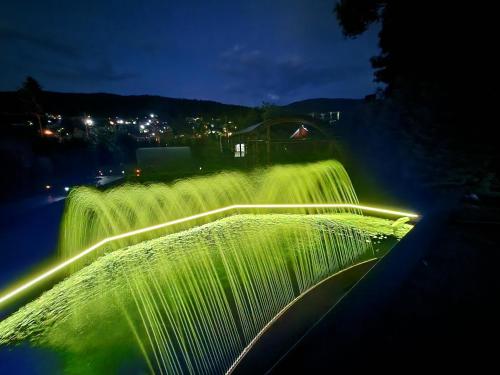 a waterfall lit up at night with green lights at Casa Turta Dulce in Buşteni