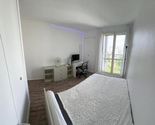 une chambre avec un lit, un bureau et une fenêtre dans l'établissement Apparemment lumineux vue Tour Eiffel, à Paris